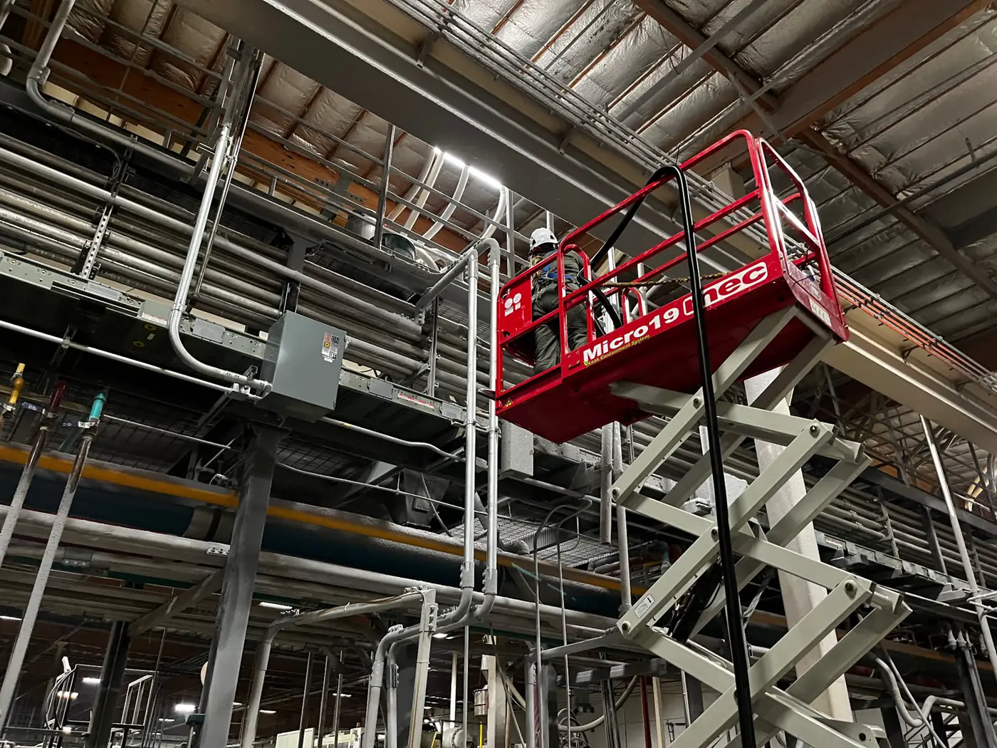 Prestige of Nevada technician working from a lift in an industrial facility