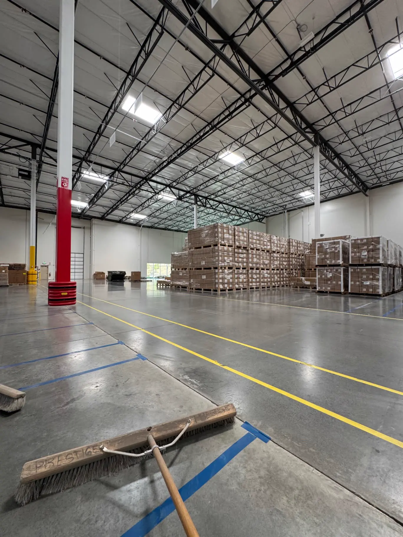 Warehouse aisle being swept during a Prestige cleaning shift